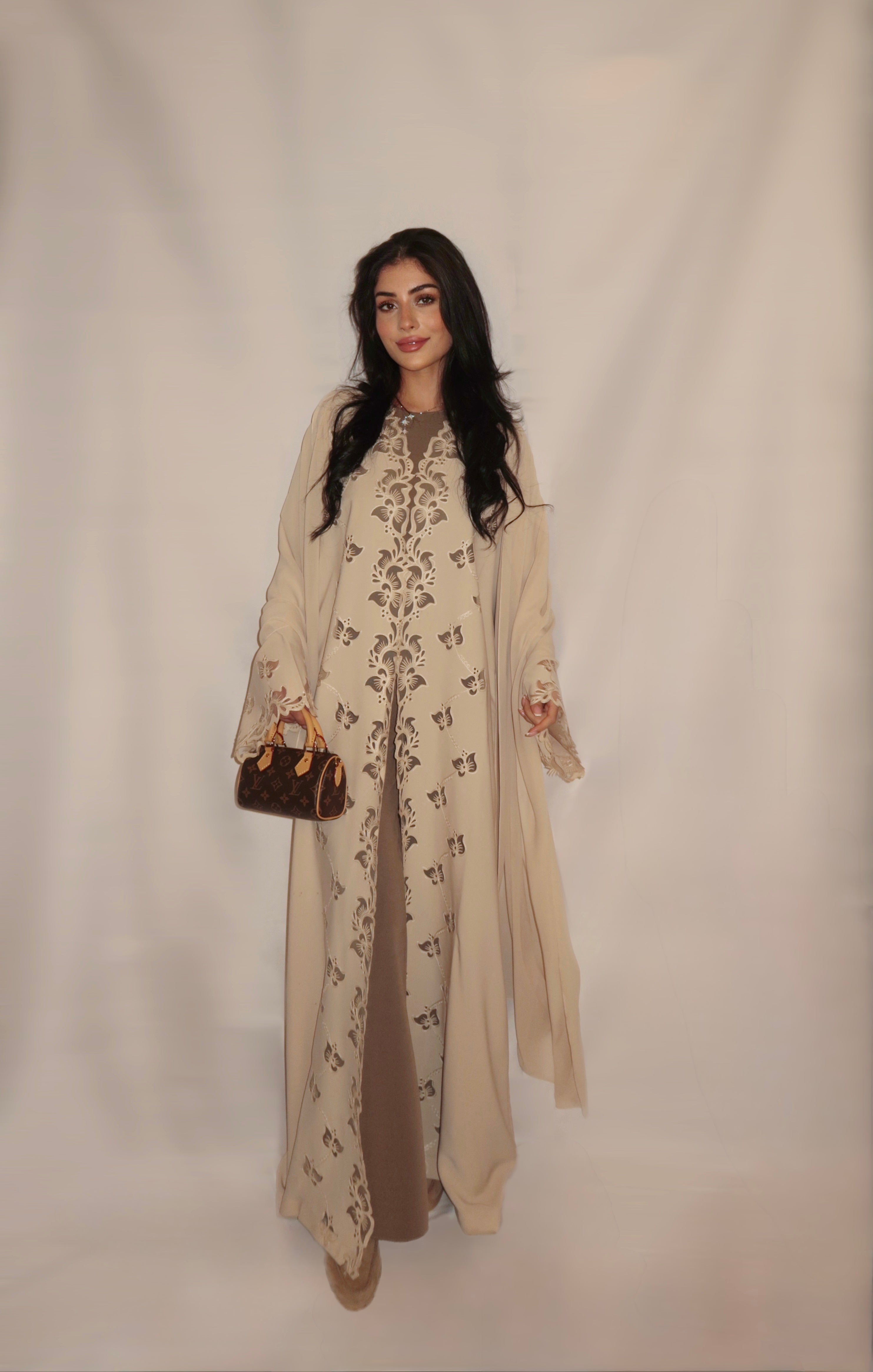 A Rima Atelier open-front abaya in ivory floral embroidery, Dubai